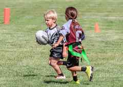 Mini Rebels youth rugby players running with the ball, with both heads visible.